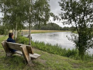 Jody tuurt over het water op het herinneringsbankje van haar moeder.